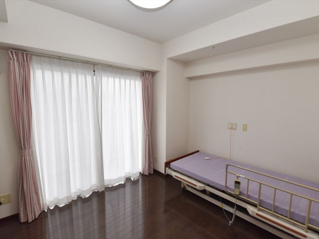 居室の明るい空間 ベッド 落ち着いた色合いの居室は、充分な広さがあり、快適な個人の時間を確保できるよう配慮されています。