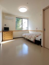 明るい居室の窓とベッド