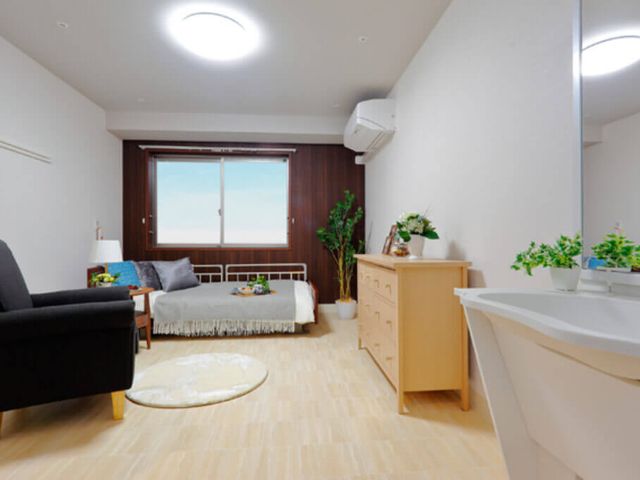 個室の室内景観 居室 広々とした室内は、明るい自然光が差し込む快適な空間です。リラックスできる家具が配置されています。