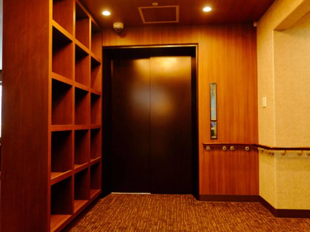 ブラウンのエレベーター エレベーター 落ち着いた雰囲気のエレベーター周辺です。手すりがあり、安全に移動できます。