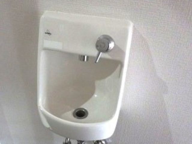 清潔な手洗い場 手洗い器 壁に設置された手洗い器は、使いやすさに配慮され清潔感があります。日々の衛生維持に役立つ環境です。
