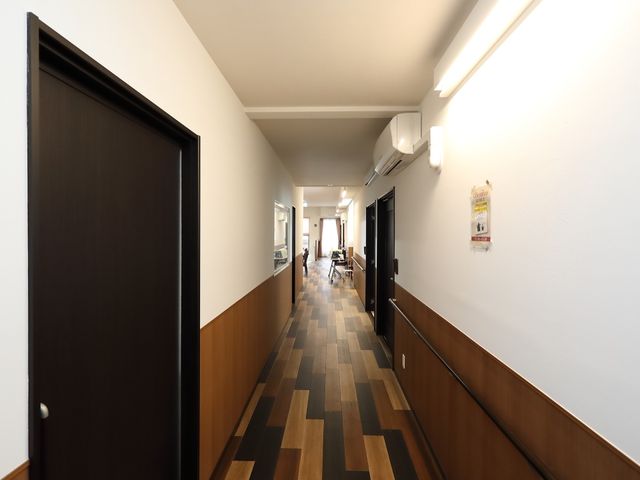 明るく広々とした施設の廊下 廊下 木目調の床が温かみを感じさせる廊下が、ご利用者様やスタッフの動線をスムーズにします。