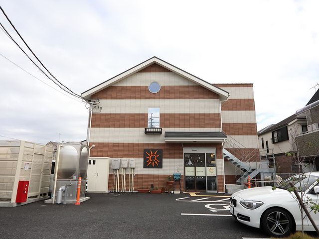 茶色の建物のエントランス 外観 清潔感のあるエントランスはバリアフリー設計で、すべての方々の出入りを容易にしています。