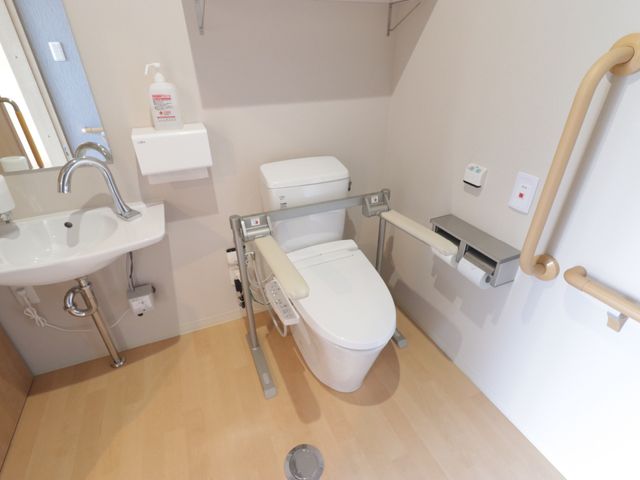 バリアフリー設計のトイレ トイレ 手すり付きで安全に配慮された明るいトイレです。利用者の自立支援を促す工夫がされています。