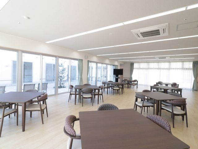 広々とした明るい食堂 食堂 ゆったり配置されたテーブルとチェアが並び、採光が明るく暖かな雰囲気の食堂です。窓からは中庭が望め、くつろぎながらお食事を楽しむことができます。