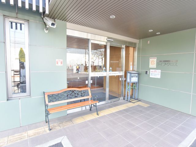 エントランスの明るい風景 玄関 清潔感あるエントランスで、来訪者を暖かく迎え入れます。ベンチも設置され、待ち時間も快適に過ごせるよう配慮がされています。