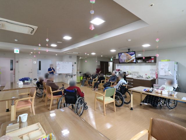 共有スペースの居心地良さ リビング・ダイニング 広々として明るい食堂では、利用者がくつろぎながら食事や会話を楽しんでいます。職員の方も笑顔でサポートしている様子が伝わります。