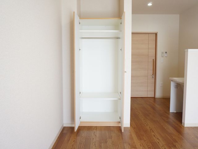 清潔な洋室のクローゼット 居室 整った空間の個室には、収納しやすいクローゼットが完備されており、快適にお過ごしいただけます。木目調のフローリングが温かみのある雰囲気を演出しています。