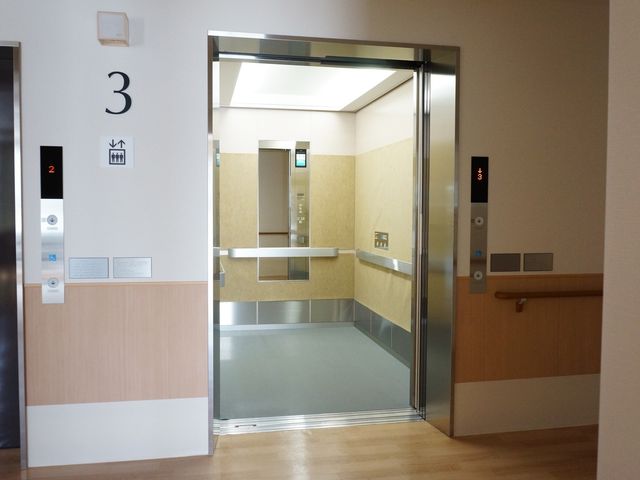 清潔なエレベーターホール エレベーター 広々として明るいエレベーターホールは、利用者様の移動を円滑にサポートします。手すりも設置されており、安全に配慮されています。