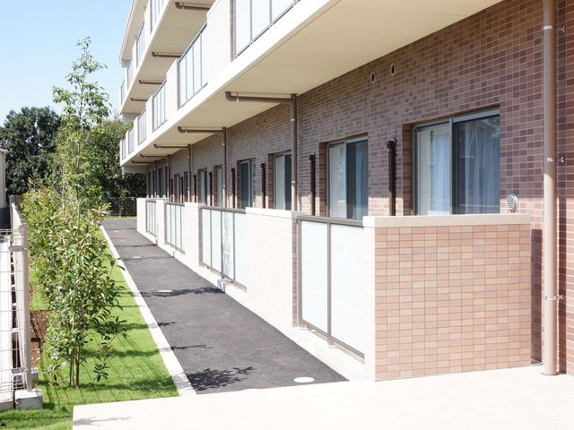 清潔な外廊下の風景 外観 手入れの行き届いた緑や清潔な通路が印象的な施設外観です。心地良い環境でお仕事ができます。