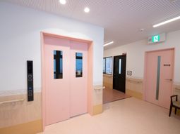 ピンクのエレベーター前廊下