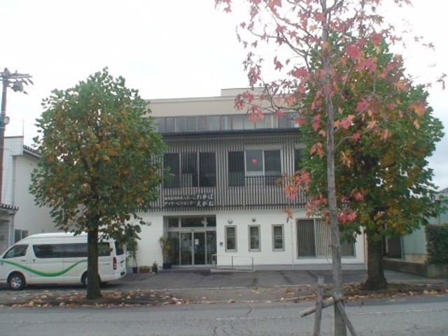 施設の落ち着いた外観 外観 白と灰色の外壁が印象的な建物です。木々に囲まれ、穏やかな雰囲気のある門前が魅力的です。