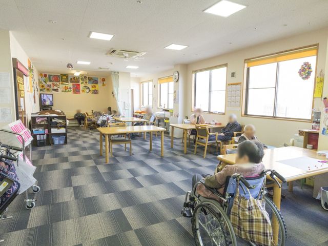 明るい共有スペースの様子 共有スペース 広々とした多目的室で、入居者様がそれぞれの時間を静かに過ごされています。様々な活動に利用可能な充実した設備が整っております。