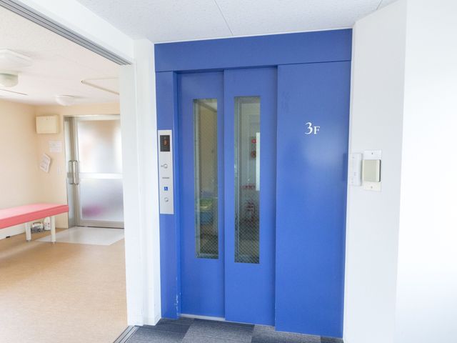 青色のエレベーター エレベーター 3階を示すエレベーターはゆとりの空間を確保しており、利便性を追及しています。日々の業務でも安心してご使用いただけます。