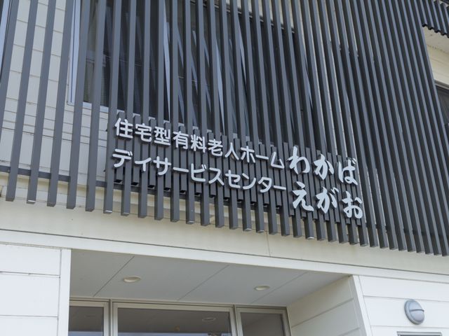 建物入口と看板 外観 明朗な建物のエントランスには、親しみやすい文字の看板が設置されており、訪れる方々を温かく迎え入れます。