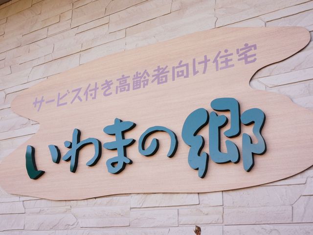 サービス名を記載した木製看板 看板 シンプルで温かみのあるデザインの看板が、訪れる人々を優しく迎え入れています。