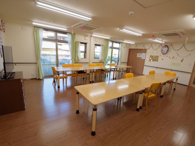明るいダイニングの様子 共有ルーム 年中行事を祝う飾り付けが施されたダイニングです。木目調の床と黄色のイスが心温まる空間を演出しています。