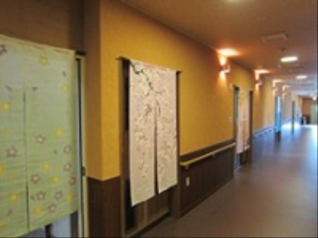温かみのある廊下 通路 廊下は暖色系の壁で包まれ、和やかな印象を与えます。ゆったりとした空間でのんびりと過ごせる環境が整っています。