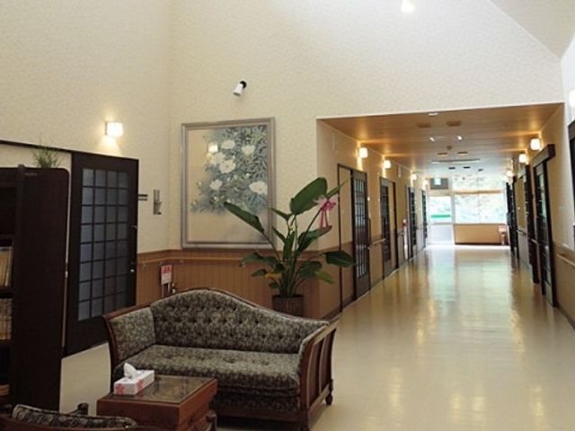 温かみのある廊下 廊下 清潔感のあふれる空間は広々としており、植物や絵画が優しい雰囲気を醸し出しています。ゆとりを持って歩ける廊下は、日々の活動に心地よさをもたらします。