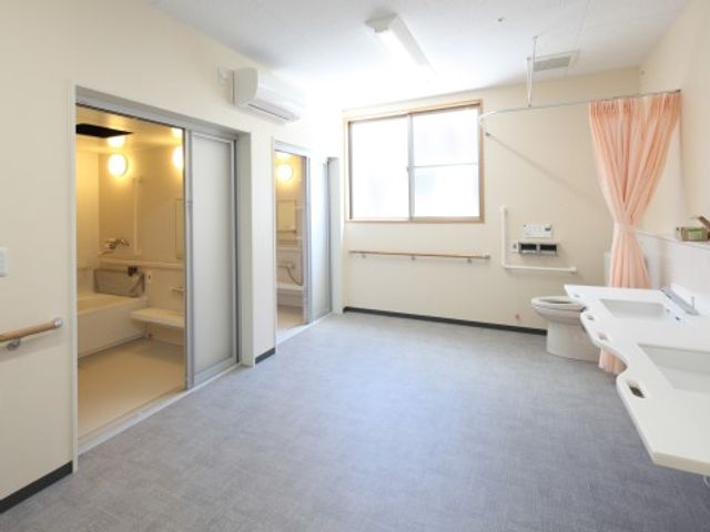 バリアフリーな洗面所と浴室 脱衣所 ゆったりとした空間のある清潔な洗面所です。手すりが付いた広々とした浴室が併設されており、安心してご利用いただけます。