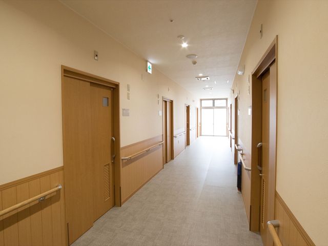廊下の明るい空間 廊下 手すり付きで広々とした廊下は、歩行に不安のある方も安心して移動できる設計です。光をたっぷり取り入れ、清潔感のある雰囲気を保っています。