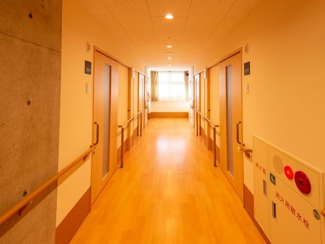 明るい廊下の様子 廊下 手すりが設置された通路は、移動を支援する配慮が感じられます。各部屋へのアクセスも考えられた安心感のある設計です。