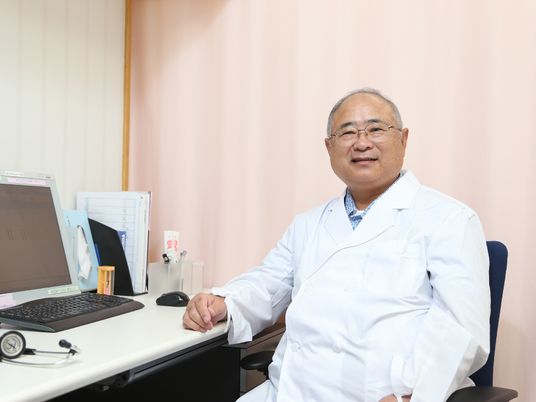 医師がオフィスで微笑む