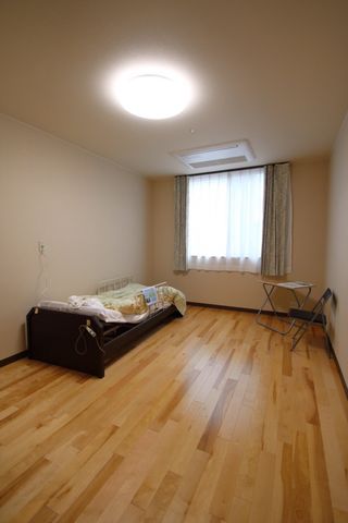 笑顔の家族三世代 居室 ご家族との心温まるひとときをサポートする広々とした中庭です。植栽に囲まれながら、孫と楽しい時間を過ごせます。