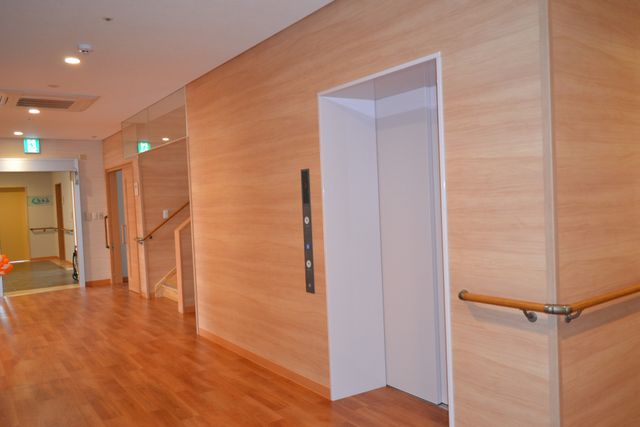 ケアスタッフと利用者の笑顔 エレベーター 温かな笑顔で利用者と接する、やりがいのある職場でのお仕事をご提供します。