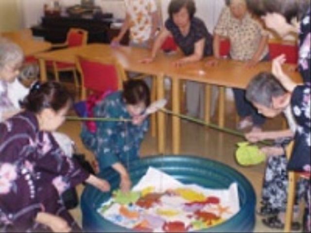 活動する笑顔の利用者様 イベント ゆったりとした空間で楽しまれているレクリエーションの様子。和気あいあいとした雰囲気が伝わります。
