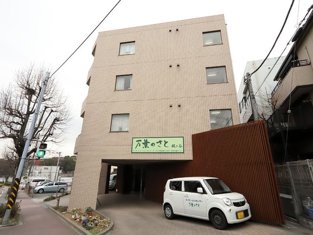 建物正面と看板 外観 木目調のデザインが印象的な建物正面は、訪れる人々を温かく迎え入れます。緑をあしらった看板が目印です。