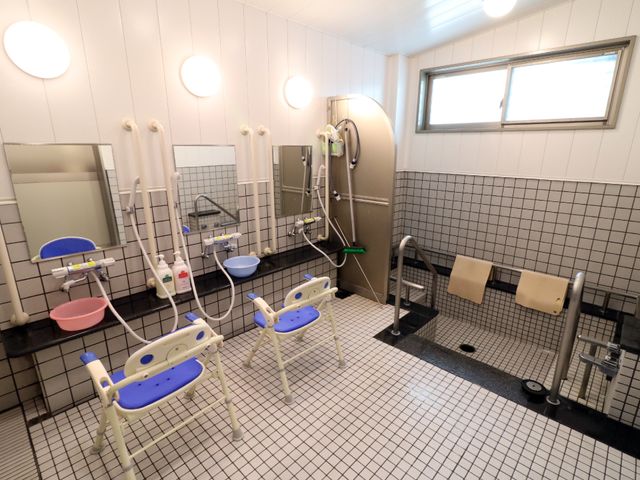 バリアフリー対応の浴室 浴室 清潔で広々とした浴室は、バリアフリー設計になっており、すべての方が安全にご利用いただけます。サポート用の椅子も備えられ、快適なバスタイムをサポートします。