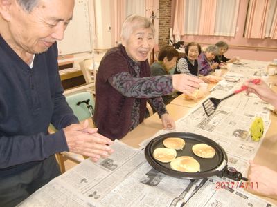笑顔で料理する高齢者たち