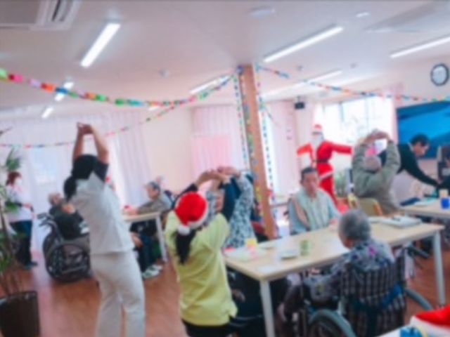 イベント中の食堂の様子 クリスマス会 広々とした食堂で開催されるイベントでは、笑顔あふれる楽しい時間を過ごすことができます。スタッフと利用者さまとのふれあいが印象的です。