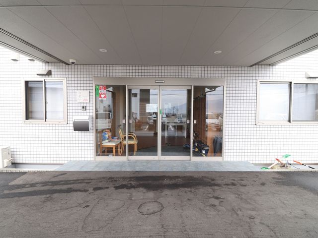 玄関前の外観 玄関 明るく開放的なエントランスは、訪れる方々を温かく迎え入れます。スタッフの働く様子も垣間見え、活気に満ちた雰囲気を感じられます。