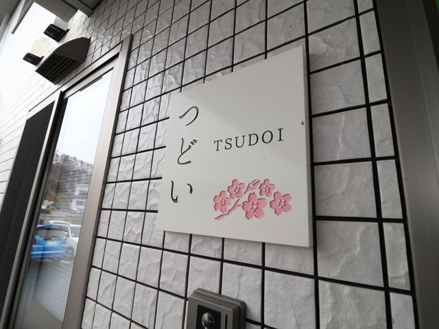 エントランスの看板 看板 洗練されたデザインのエントランスを持つ施設で、あたたかみを感じさせる花のイラストが印象的です。訪れる方々を明るく迎えます。