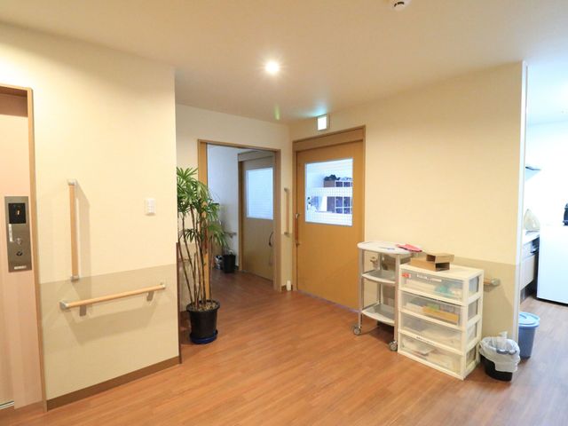 清潔感ある廊下の様子 通路 温かみのある色合いの床と壁が、訪れる人々に安らぎを提供しています。手すりがついており、安全に配慮された造りになっています。