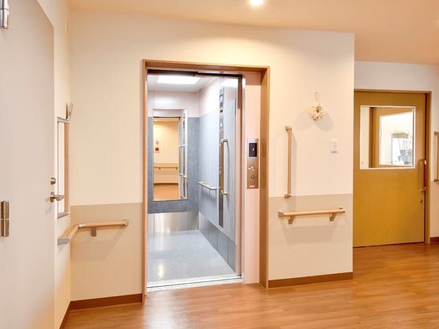 バリアフリーな廊下 エレベーター すっきりとした廊下には、壁に手すりが備え付けられており、安全に配慮された設計です。また、明るい雰囲気で訪れる方を温かく迎えます。