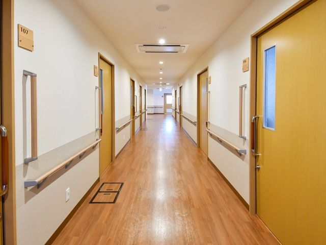 手すり付きの明るい廊下 廊下 床が木目調で、手すりが設置された広々とした廊下です。自由に歩行訓練が行え、安心してお過ごしいただけます。