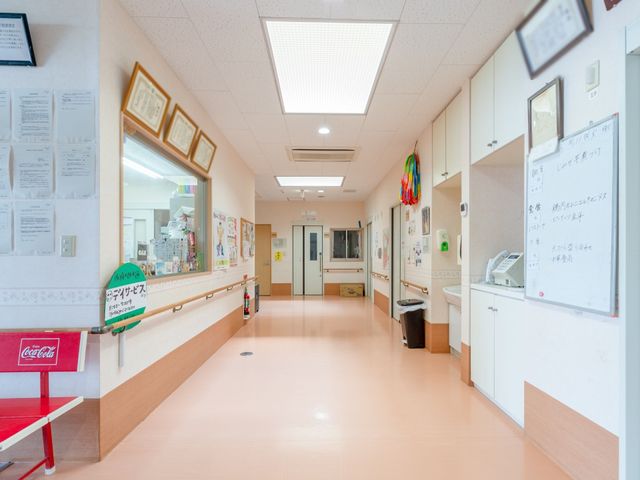 明るい廊下の風景 通路 広々とした廊下には、情報を伝える掲示物が整然と配され、快適な移動やコミュニケーションが行える工夫が見られます。