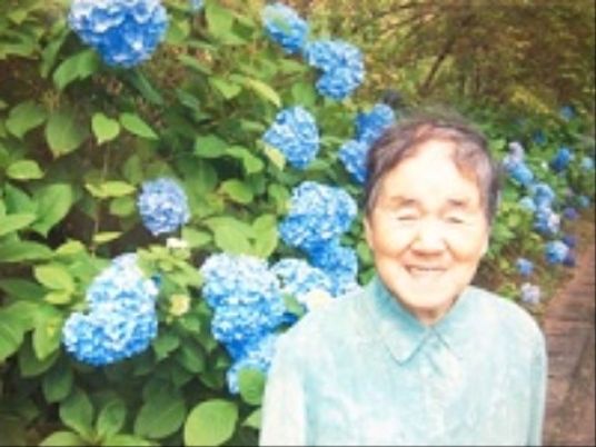 笑顔の女性とアジサイの庭