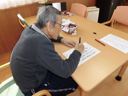 高齢者が筆記活動を行う様子