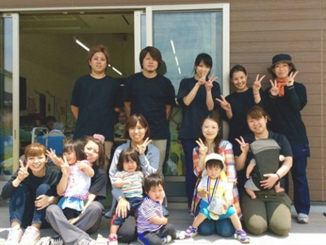 にこやかなスタッフと子供たち スタッフ 笑顔あふれるスタッフと子供たちが、明るく開放的な雰囲気の中で楽しく過ごしています。チームワークの良さが感じられる場面です。