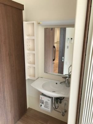 洗面台とシェルフのある居室