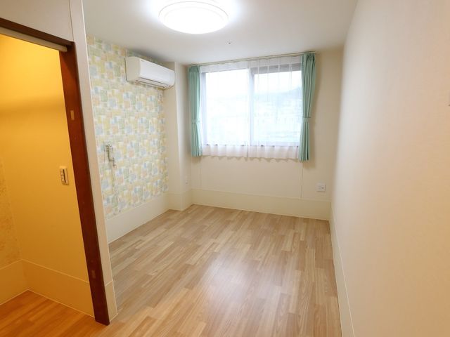 空の明るい洋室内部 居室 ゆったりとした居室は、柔らかな光が差し込む窓と清潔感のある内装で、心地よい時間を過ごせます。エアコン完備で、季節を問わず快適です。