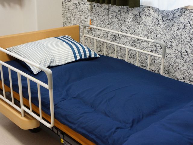 清潔な居室のベッド スライドショー 使いやすい設計の居室です。安全手すり付きのベッドで、快適な休息を提供しています。