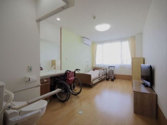 明るい広々とした居室 居室 ゆとりのある居室は、機能的な家具と光がたっぷり差し込む窓で明るい雰囲気を演出しています。ベッドの横には車椅子も置けるスペースがあります。