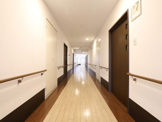 掃除が行き届き、壁と天井がアイボリーの明るい廊下である。居室のドアは焦げ茶色で、廊下のアクセントになっている。