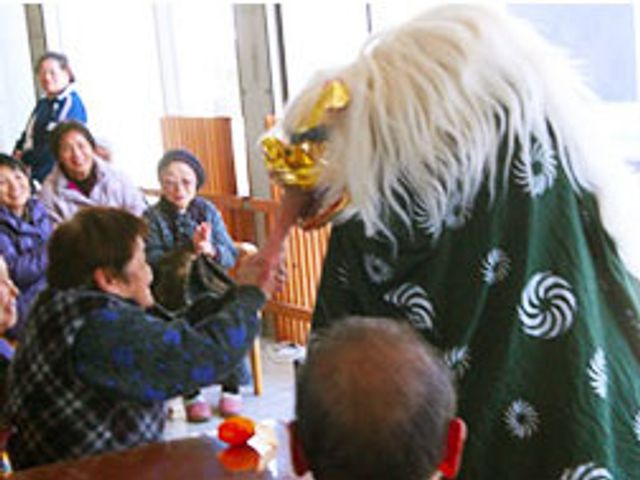 獅子舞のパフォーマンス イベント 獅子舞が行われ、見守る人々が笑顔で交流しています。この活動は日々の生活に潤いを与え、心のリフレッシュにも繋がります。