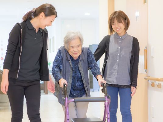 歩行訓練中の高齢者とスタッフ